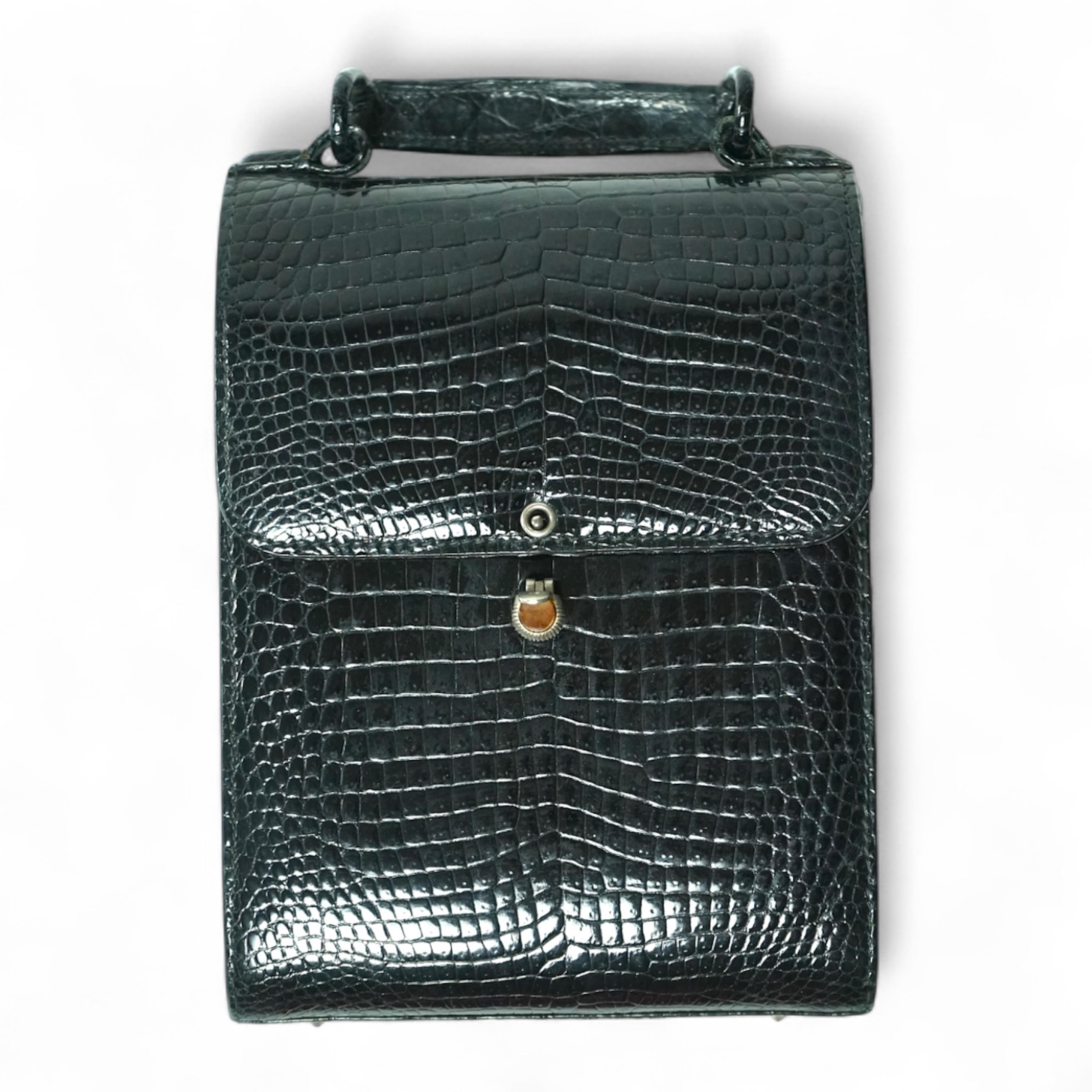 A stylish 1930’s lady’s Asprey of London, black lizard skin evening bag with ornamental amber coloured Bakelite clasp. 23cm high from handle to base. Condition- some internal scratches to lining as expected for age and u